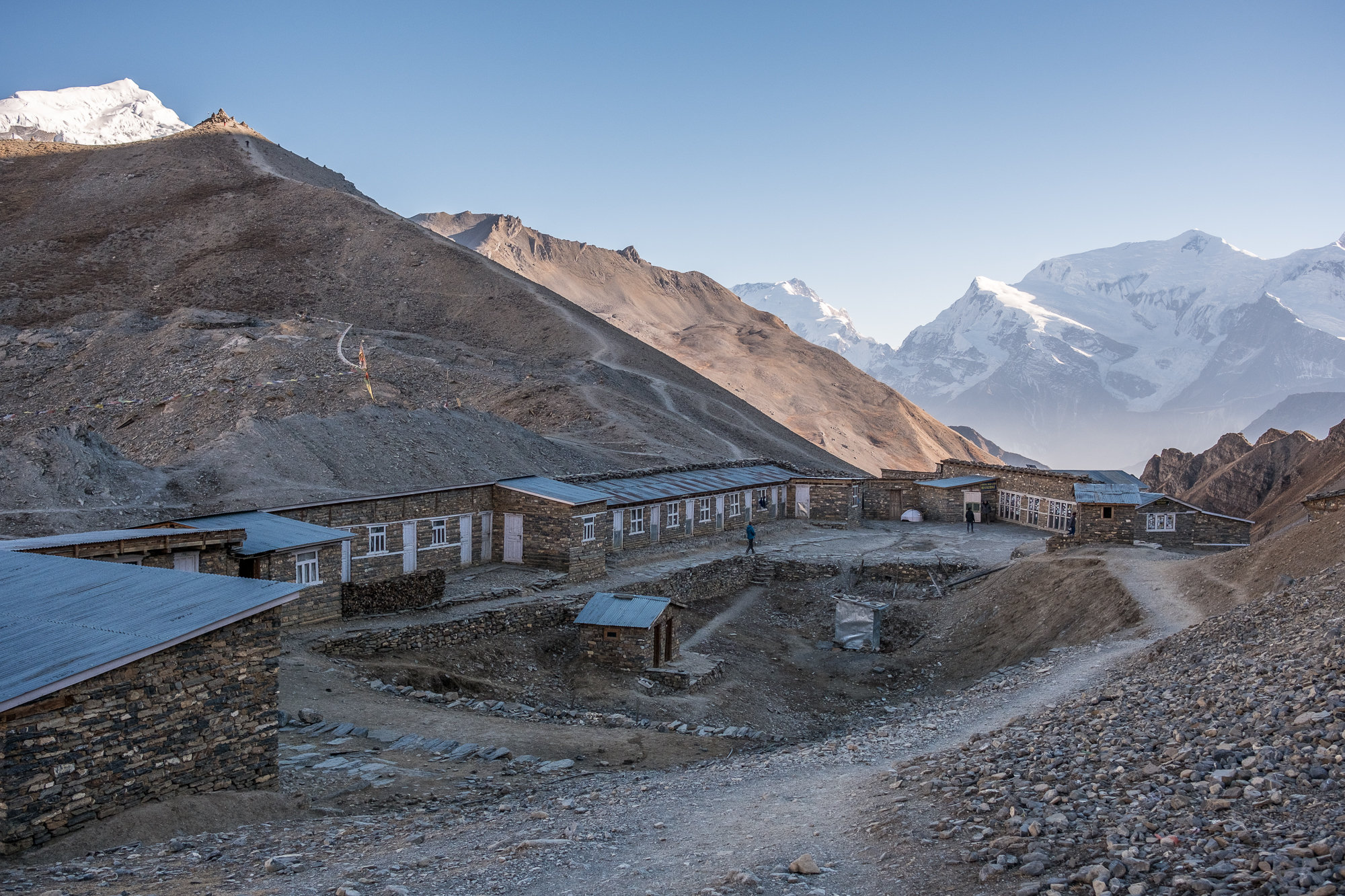 Thorung Pedi High Camp, with a view on shared rooms (with two beds) and restrooms. The last building is the main area with the kitchen. Don’t forget your down jacket(s), even inside.